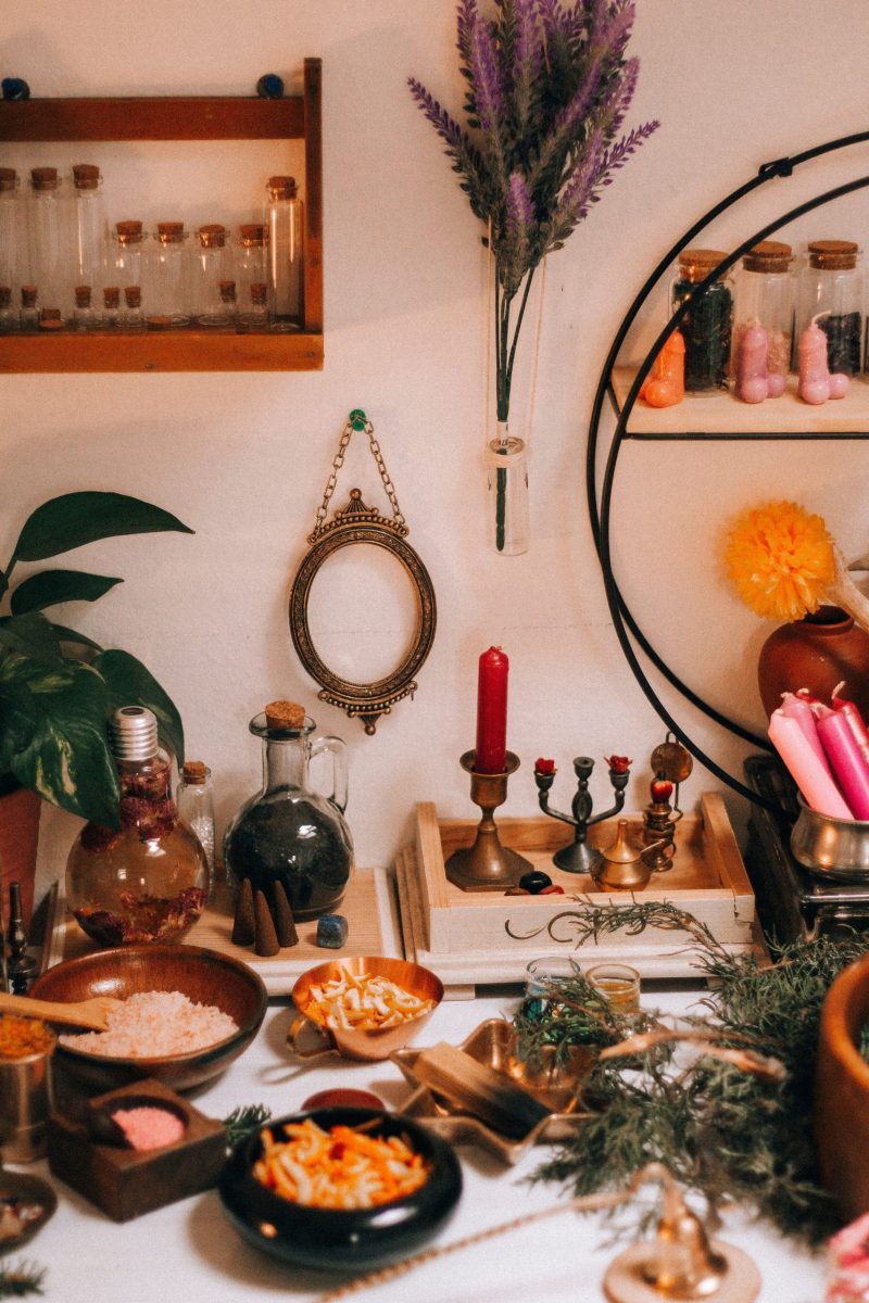 A cozy artisan workspace adorned with candles, herbs, and mystical elements, evoking a magical ambiance.